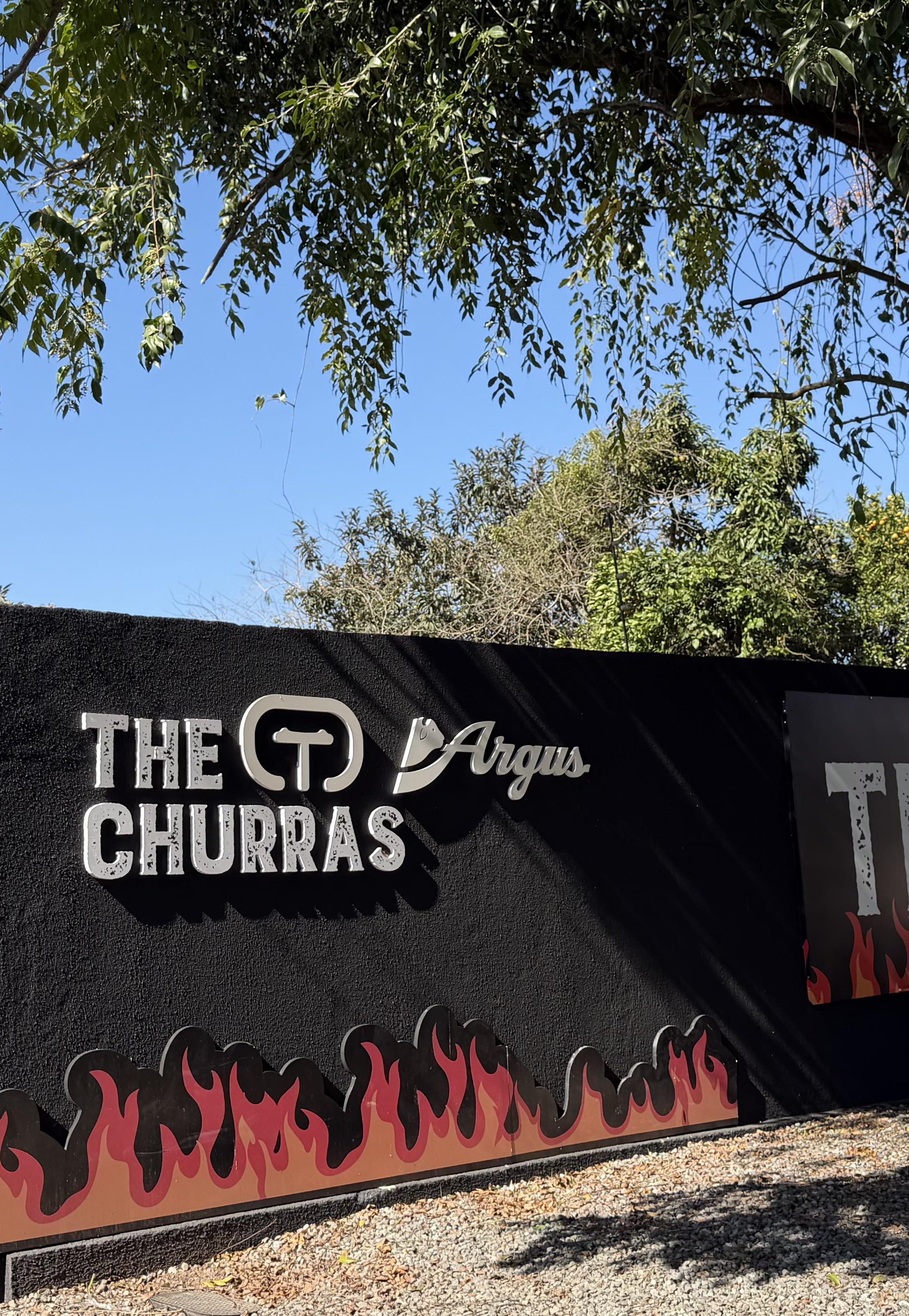 Fachada da THE CHURRAS com sinalização e chamas